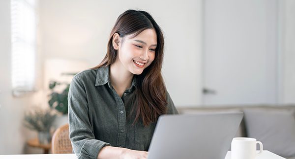 Woman sitting at her computer smiling